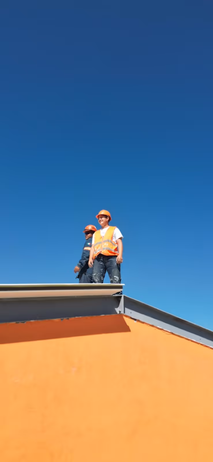 Dachdecker montiert Ziegel auf Steildach bei Dachsanierung